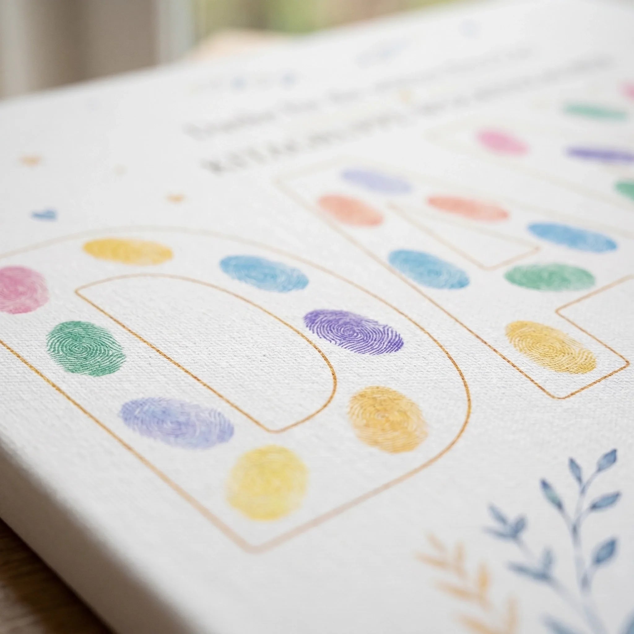 Gästebuch mit farbigen Fingerabdrücken und goldenen Rahmenlinien, unscharfer Hintergrund, nahes Detail - Feed