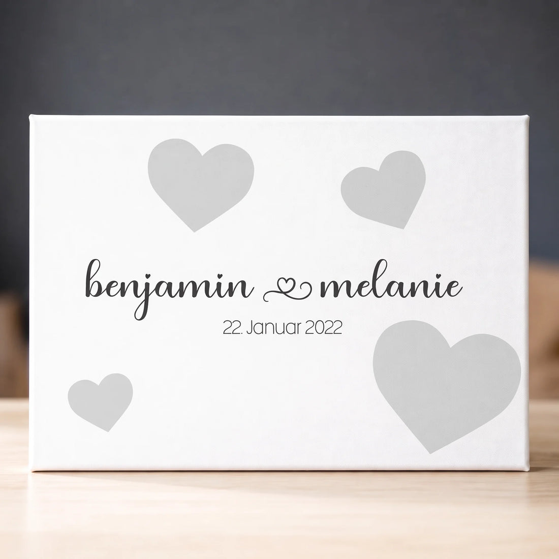 Personalisierte Gästebücher als weiße Leinwand mit Namen Benjamin und Melanie, Datum und grauen Herzen